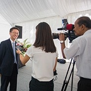 Man being interviewed in front of a cameraman at an event.