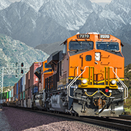 Train engine and raid cars on track through mountains.