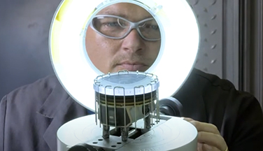 Worker rating engine part / piston using round light.